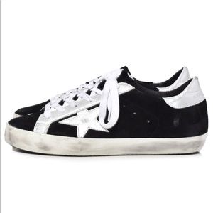 Low top black suede sneakers with silver stars
